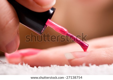 Woman applying red nail polish