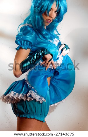 woman wearing  blue dress and wig against the wall with fancy light pattern