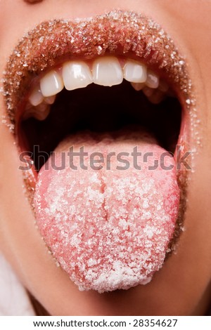 Closeup of beautiful woman lips and tongue covered by sugar