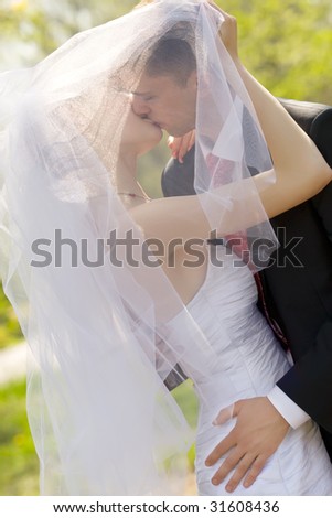 Colorful wedding shot of bride and groom kissing