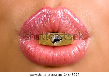 woman holding metal padlock with keyhole in her mouth