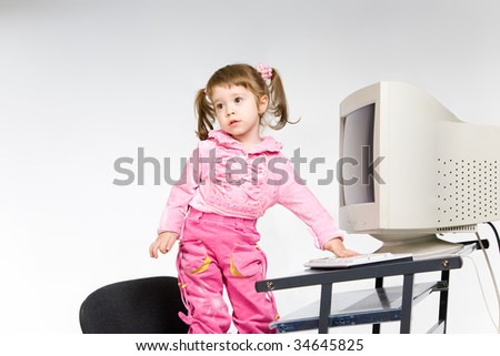 Little girl playing with desktop computer