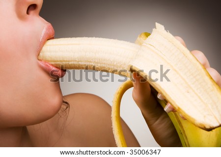 Young woman eating banana in own sexy style