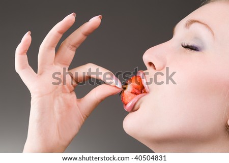 woman eating juicy strawberry, eyes closed of pleasure