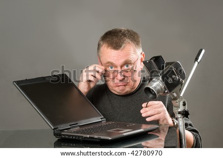 Mature age photographer with laptop and camera
