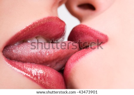 Beautiful female lovers kissing with tongues out