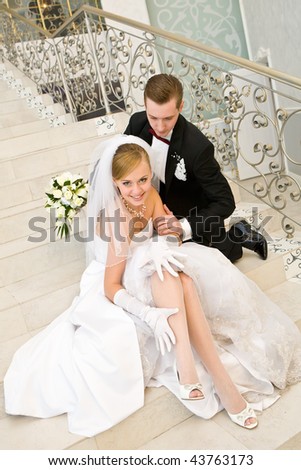 stock photo Bride and groom sitting on marble stairs