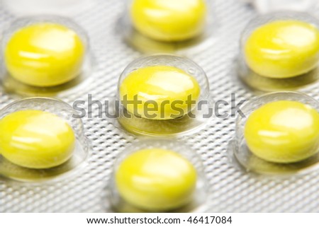 Macro shot of yellow pills` set  isolated on white back round