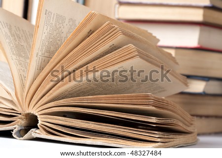 Opened big book against pile of books