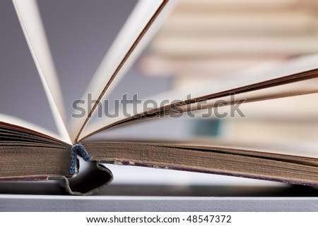 Opened big book against pile of books