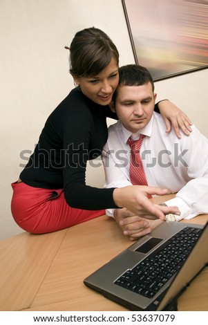 Pair of managers communicating, working on laptop computer