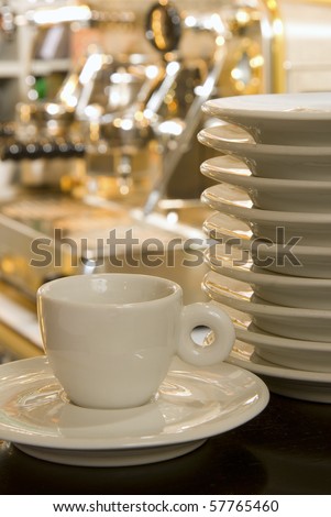 Coffee cup with plates on the blurred coffee-mashing background
