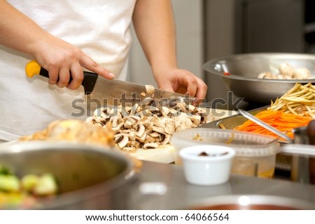 Chef cutting the mushrooms on a wooden board