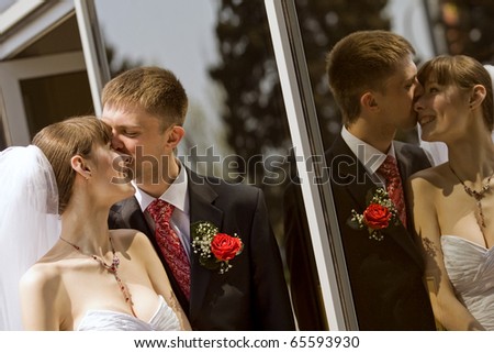 Reflection of happy bride and groom in the mirror outdoor