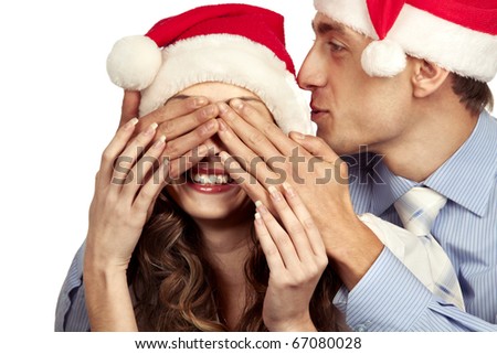 Young man covering the eyes of her girlfriend. Isolated over white background