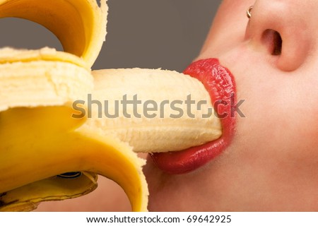 Close-up female mouth eating peeled banana