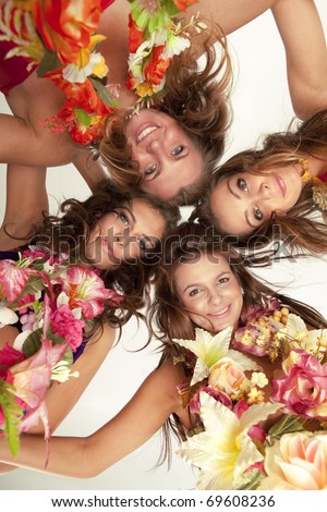 Low angle view of happy beautiful hawaiian Hula Dancer Girls standing together in a circle