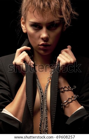 Beautiful woman wearing black jacket with chains on her arms and neck