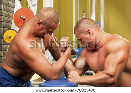 Couple of muscular men measuring forces, isolated on white