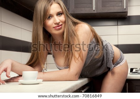 Beautiful young sexy woman drinks hot coffee at home