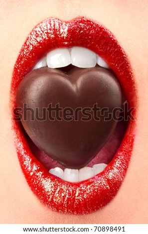 Closeup of woman lips with chocolate candy