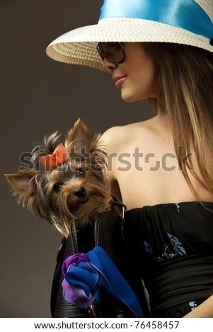 Profile of young glamor woman with Yorkshire Terrier dog in her bag