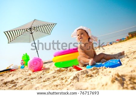 Little baby girl on the sand beach with beach toys Little baby girl on the sand beach with beach toys