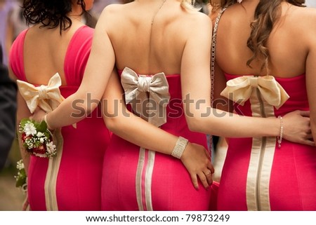 Rear view of bridesmaids with boutonnieres on their hands at wedding ceremony