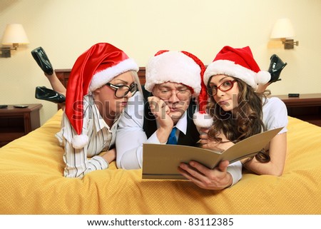 Manager with two his subordinates reading a business plan on New Year\'s night