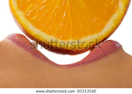 Profile of open female mouth with orange slice over white background