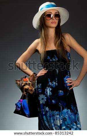 Young glamor woman with Yorkshire Terrier dog in her bag