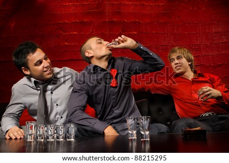 Men drinking shots in night club