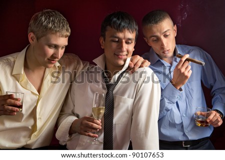 Three friends drinking a whisky and smoking a cigar