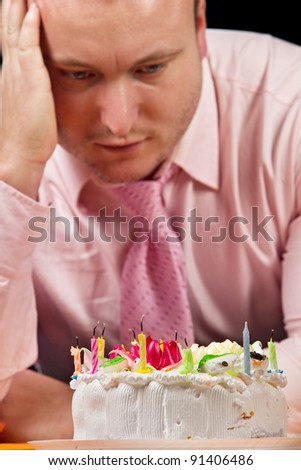 Sad birthday man with cake and candle