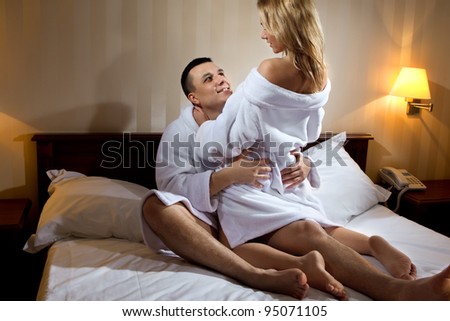 Young couple hugging on the bed in bedroom