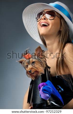 Profile of young glamor woman with Yorkshire Terrier dog in her bag