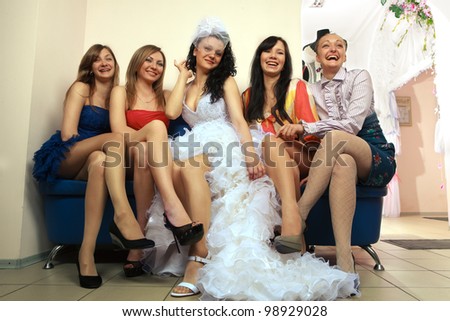 Bride sitting with girlfriends in professional fashion designer studio