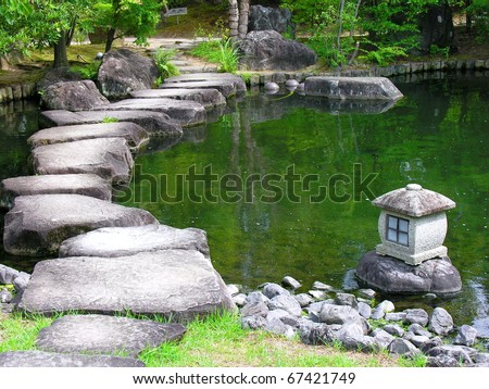 Japan zen path in a garden, pond surrounded