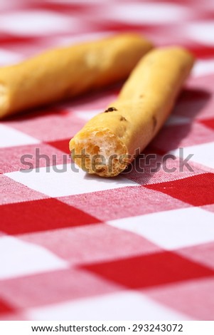 Bread sticks gingham tablecloth Bread sticks with onion on a gingham tablecloth.