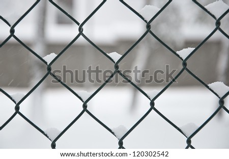 mesh metal fence covered with snow