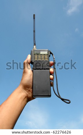 hand hole walky talky with blue sky background - stock photo
