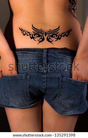 Sexy topless girl with tribal dragon tattoo on her back