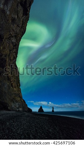 Northern Lights above Vik beach and cliffs in Iceland