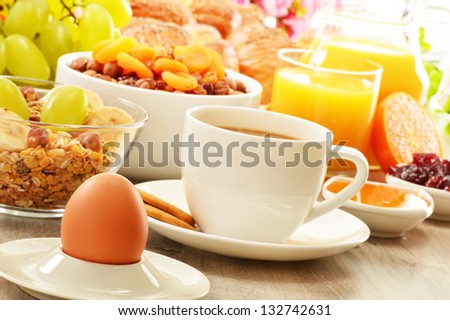 Breakfast including coffee, bread, honey, orange juice, muesli and fruits