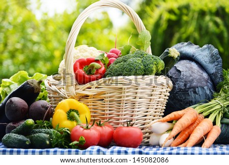 Assorted vegetables in wicker basket in the garden