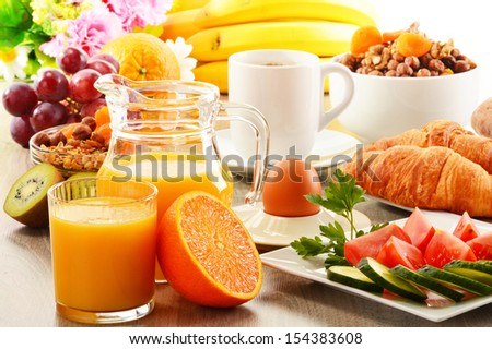 Breakfast with coffee, orange juice, croissant, egg, vegetables and fruits