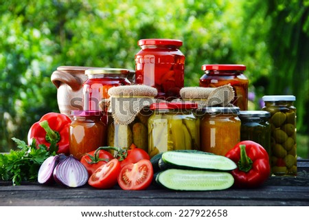 Jars of pickled vegetables in the garden. Marinated food.