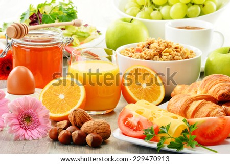 Breakfast consisting of fruits, orange juice, coffee, honey, bread and egg. Balanced diet