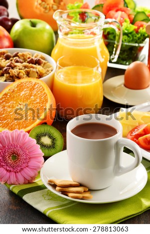 Breakfast consisting of fruits, orange juice, coffee, honey, bread and egg. Balanced diet.