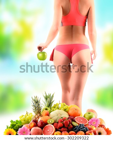 Weight loss. Slim woman holding an apple and composition with variety of fresh fruits.